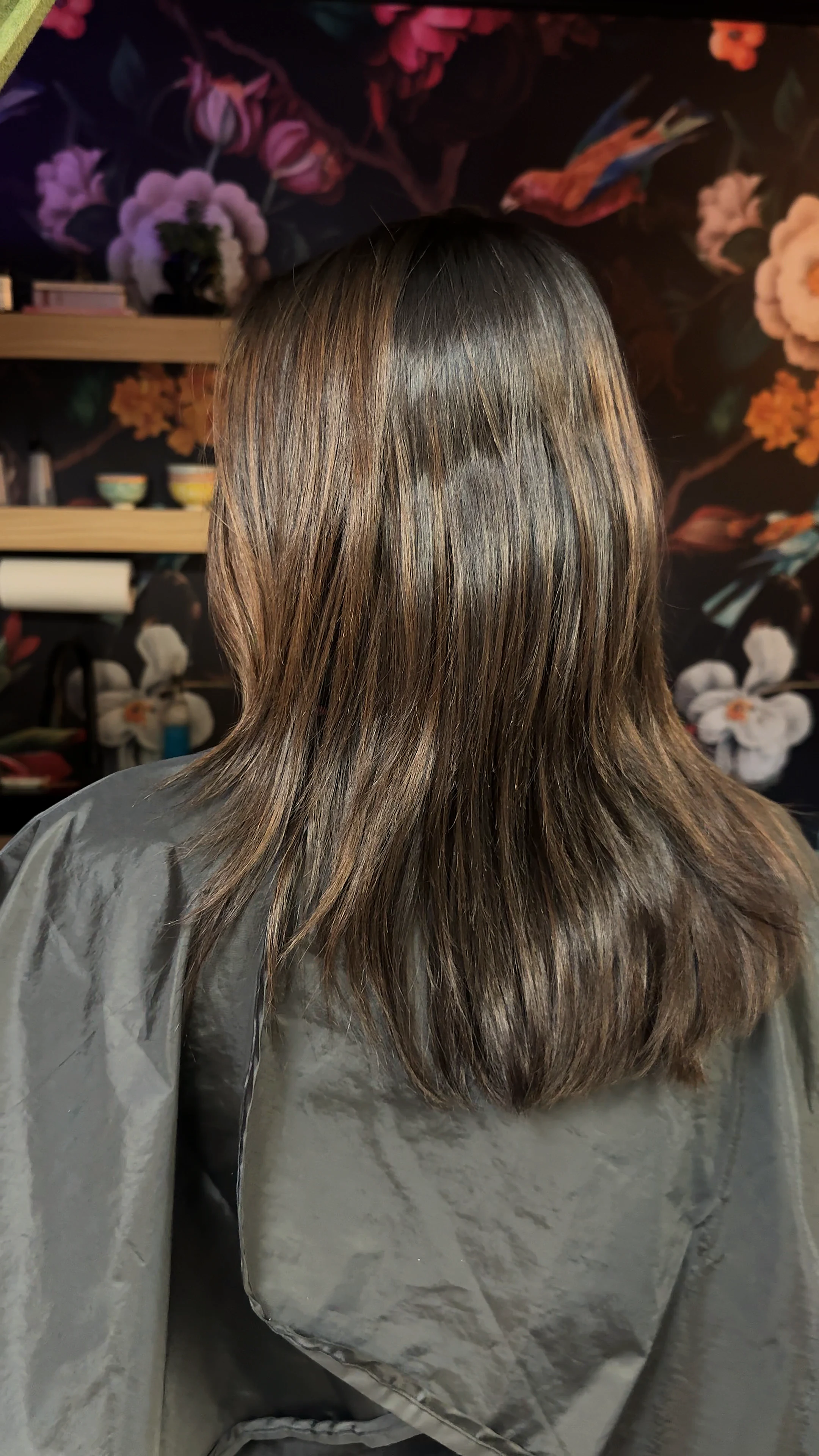 Finished honey-blonde set against the dark floral mural