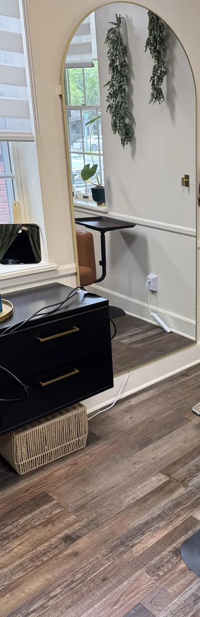 The arched full-length mirror with its warm backlight