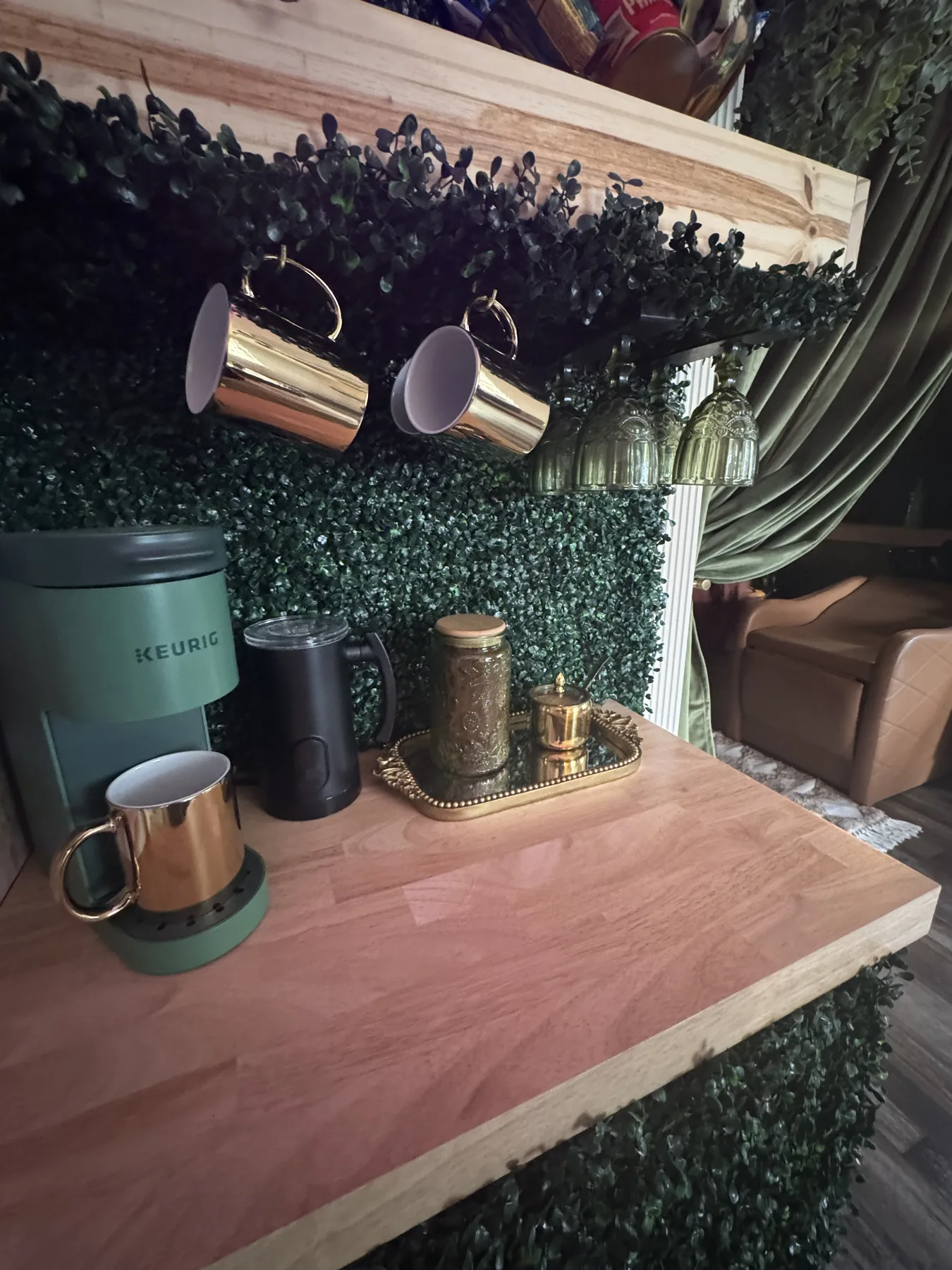The refreshment bar: gold mugs on the boxwood wall